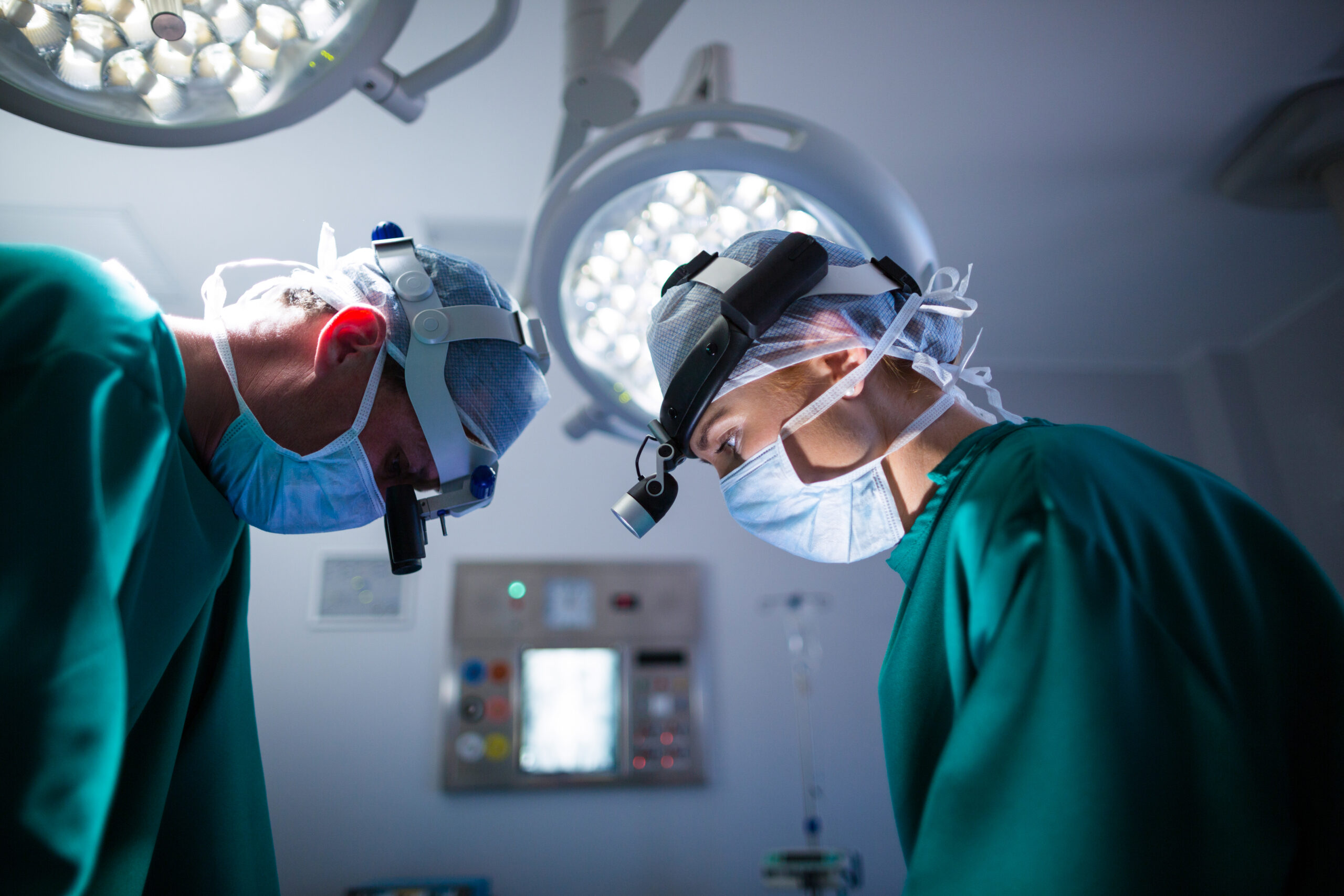 surgeons wearing surgical loupes while performing operation scaled